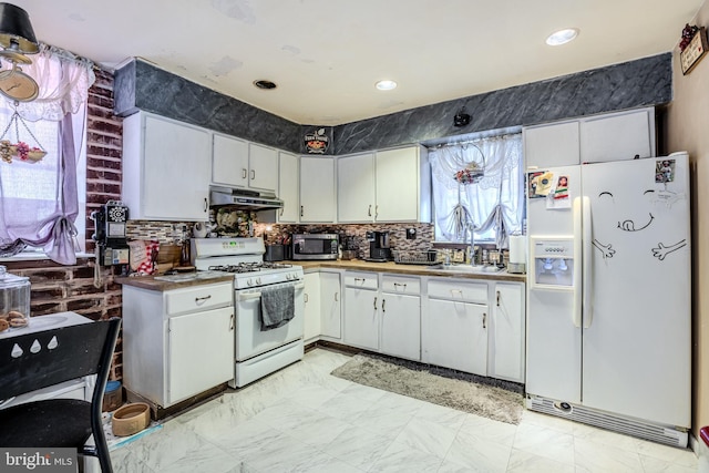 kitchen featuring white appliances, backsplash, white cabinetry, and under cabinet range hood