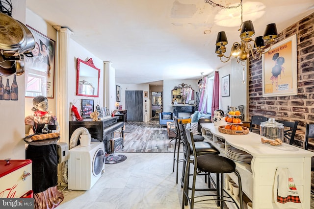 dining space with a notable chandelier and brick wall