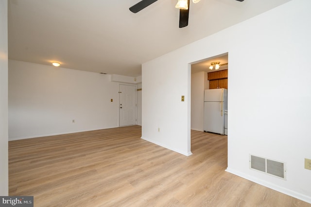 unfurnished room featuring light wood-style floors, ceiling fan, and visible vents