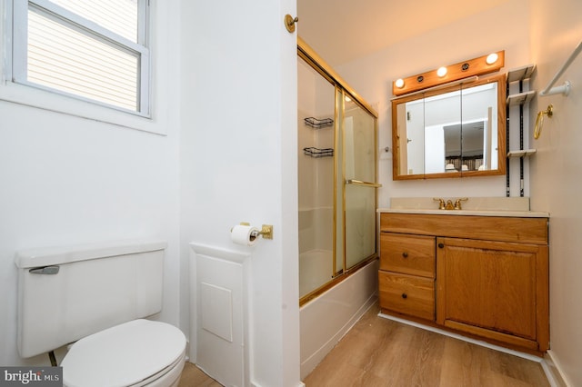 full bathroom featuring combined bath / shower with glass door, vanity, toilet, and wood finished floors