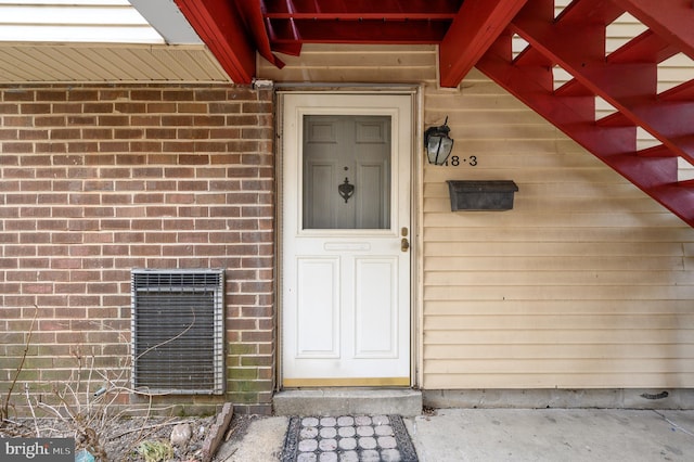 doorway to property featuring brick siding