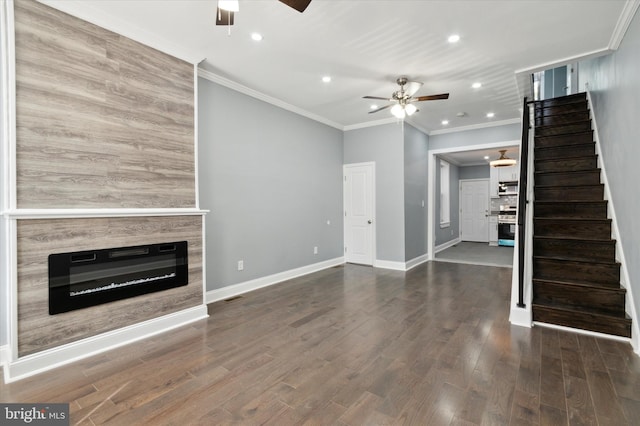 unfurnished living room with a ceiling fan, baseboards, stairs, dark wood-style floors, and a glass covered fireplace