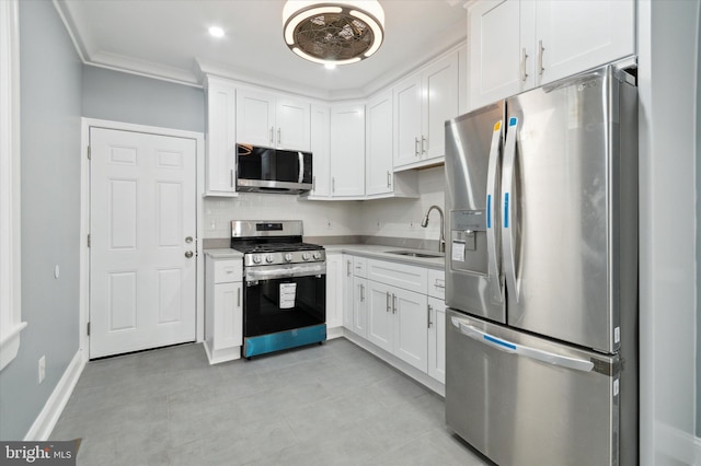 kitchen featuring crown molding, light countertops, appliances with stainless steel finishes, white cabinetry, and a sink