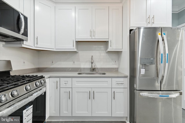 kitchen featuring tasteful backsplash, appliances with stainless steel finishes, light countertops, white cabinetry, and a sink