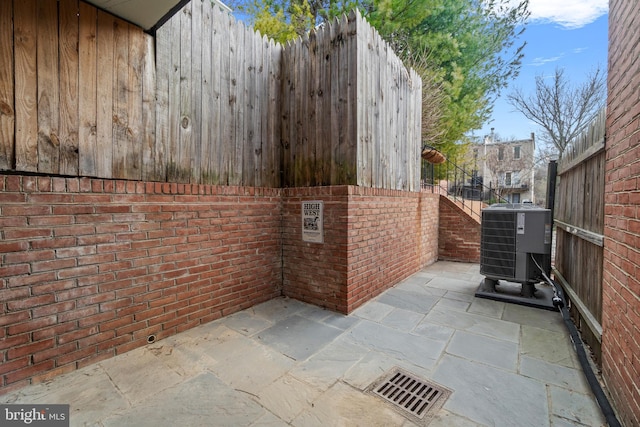 view of patio / terrace with central AC unit and fence