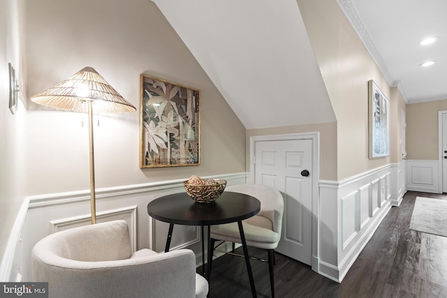 interior space featuring lofted ceiling, a wainscoted wall, ornamental molding, dark wood-type flooring, and recessed lighting