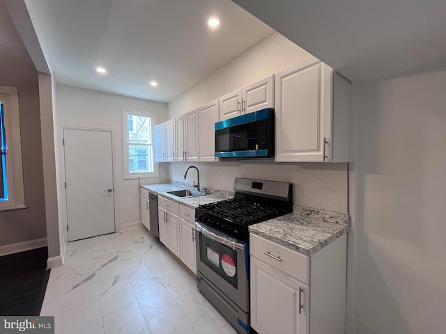 kitchen featuring a sink, white cabinetry, marble finish floor, dishwasher, and stainless steel range with gas stovetop