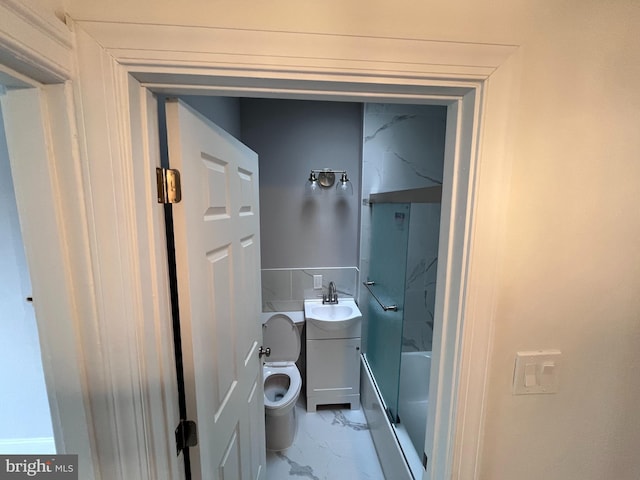 bathroom featuring toilet, marble finish floor, bathing tub / shower combination, and vanity