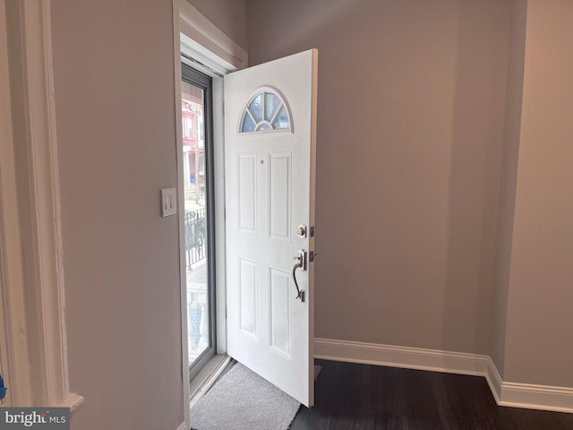 entrance foyer with dark wood-type flooring and baseboards