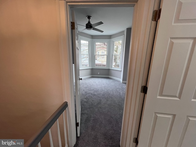 corridor with carpet and baseboards