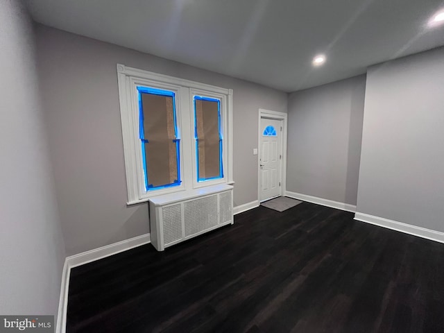 entrance foyer featuring recessed lighting, radiator, dark wood finished floors, and baseboards