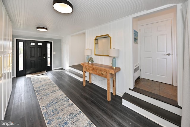 entrance foyer with dark wood-style floors, baseboards, and radiator