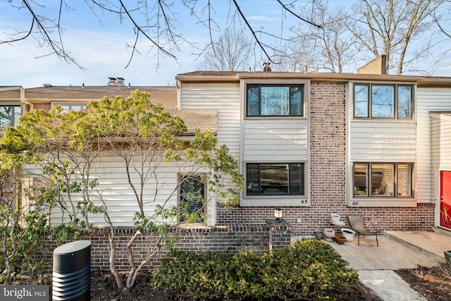 rear view of house with brick siding