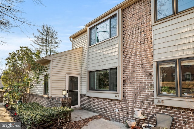 view of exterior entry featuring brick siding