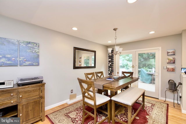 dining space with light wood-style floors, baseboards, a notable chandelier, and recessed lighting