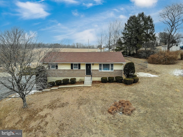 single story home featuring a front lawn and brick siding