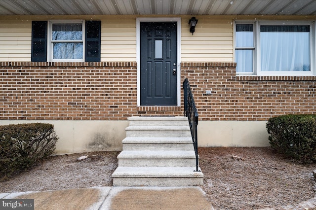 view of exterior entry with brick siding