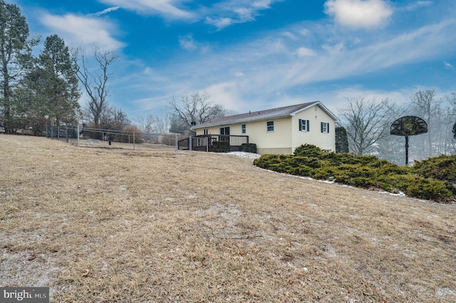 exterior space featuring a yard, fence, and a wooden deck