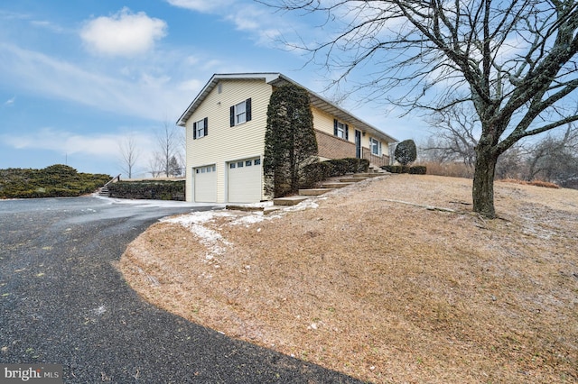 view of side of property with a garage and driveway