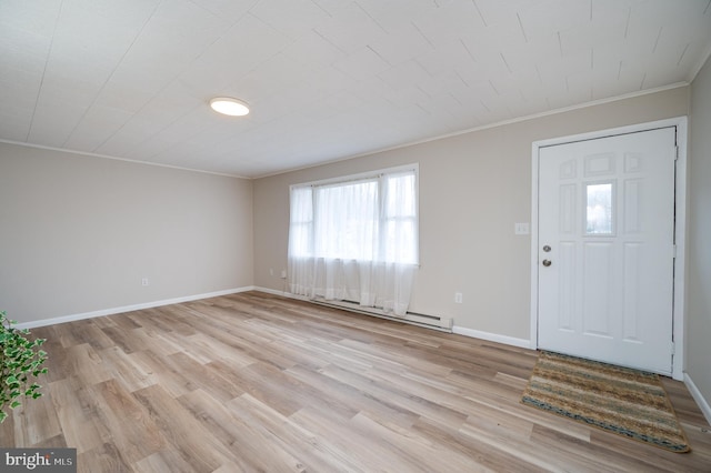 foyer with crown molding, baseboard heating, light wood-type flooring, and baseboards