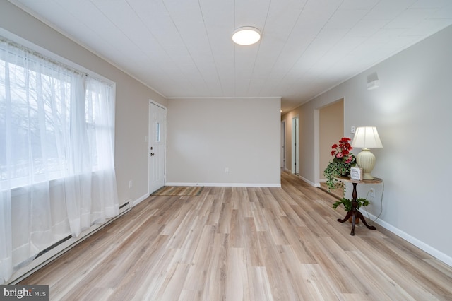 spare room featuring baseboards and light wood-style floors