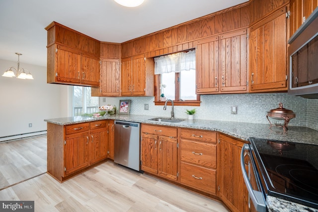 kitchen with stainless steel appliances, hanging light fixtures, a sink, and brown cabinets