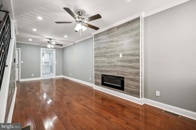 unfurnished living room with crown molding, visible vents, a large fireplace, wood finished floors, and baseboards