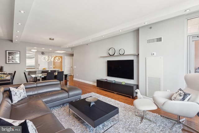 living room featuring recessed lighting, visible vents, baseboards, and wood finished floors