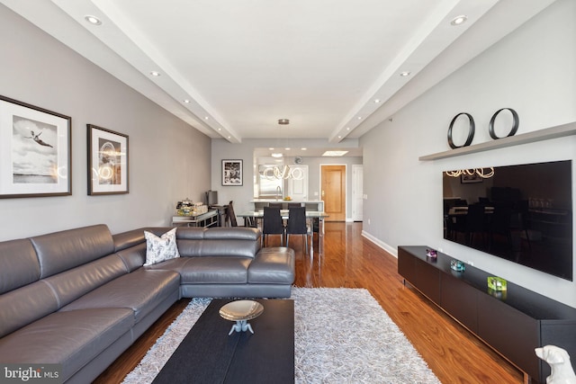 living area with baseboards, wood finished floors, and recessed lighting