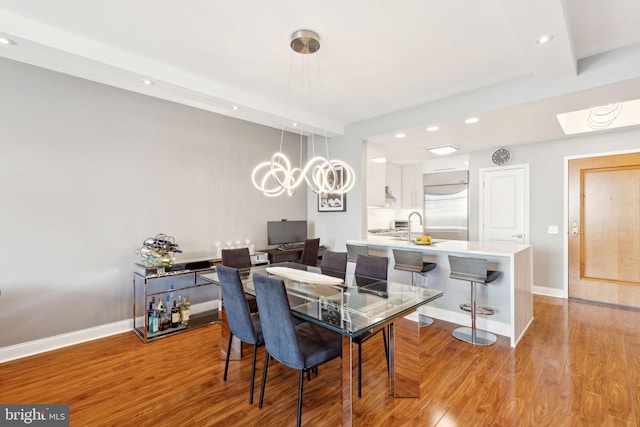 dining area with light wood-type flooring, baseboards, and recessed lighting