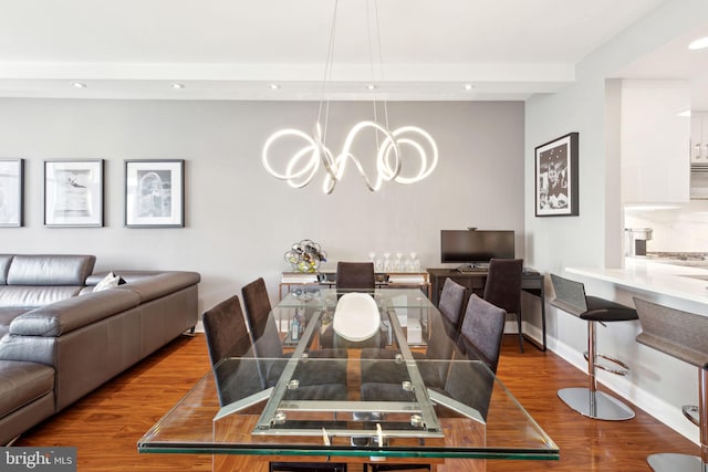 dining room with a chandelier, baseboards, wood finished floors, and recessed lighting