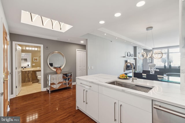 kitchen with dark wood-type flooring, white cabinets, a sink, and recessed lighting