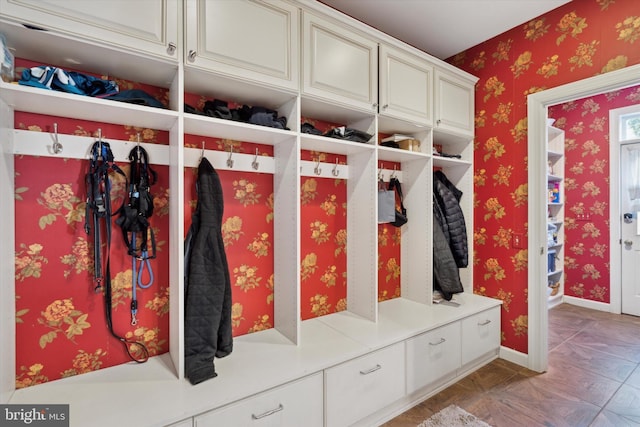 mudroom with wallpapered walls and baseboards