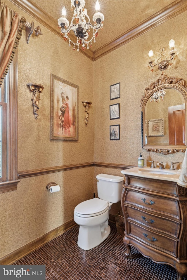 bathroom with wallpapered walls, toilet, ornamental molding, an inviting chandelier, and vanity