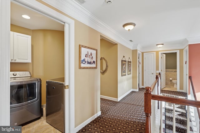 hall with independent washer and dryer, baseboards, crown molding, and an upstairs landing