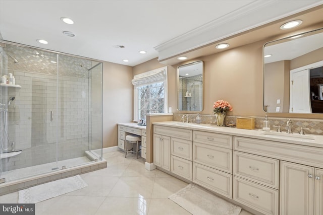 bathroom with double vanity, a stall shower, a sink, and tile patterned floors