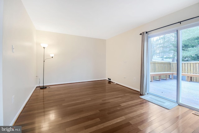 empty room featuring dark wood finished floors and baseboards