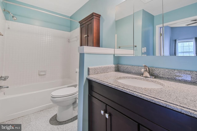 bathroom featuring toilet, speckled floor, tub / shower combination, and vanity