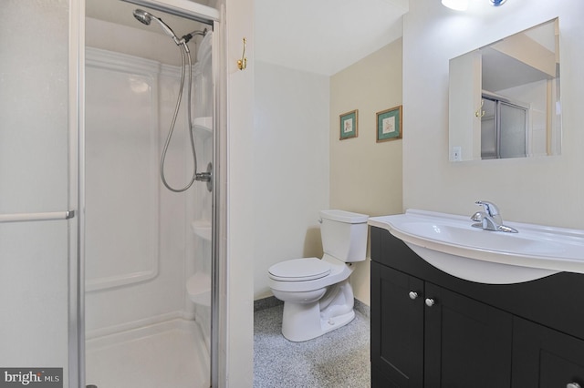 full bathroom featuring a stall shower, baseboards, toilet, vanity, and speckled floor