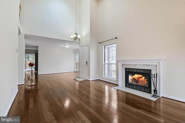 unfurnished living room with a fireplace, wood finished floors, and baseboards