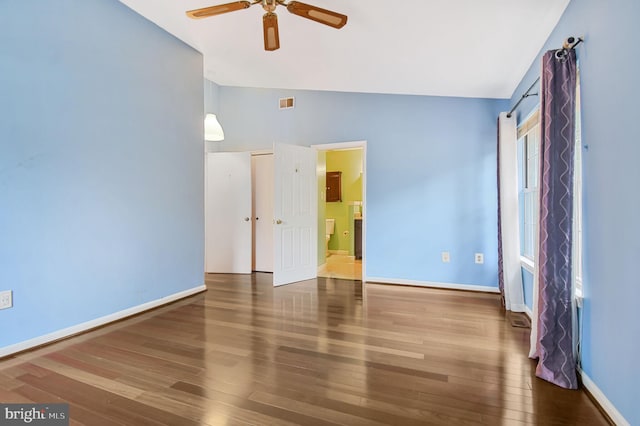 unfurnished bedroom with lofted ceiling, visible vents, baseboards, and wood finished floors