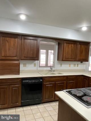 kitchen with black dishwasher, recessed lighting, cooktop, light countertops, and a sink