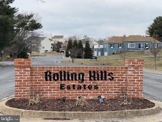 community / neighborhood sign with a residential view and aphalt driveway