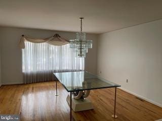 unfurnished dining area featuring baseboards and wood finished floors