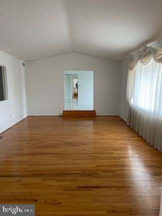 unfurnished living room featuring vaulted ceiling and wood finished floors