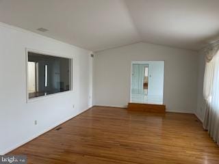 unfurnished living room featuring vaulted ceiling and wood finished floors