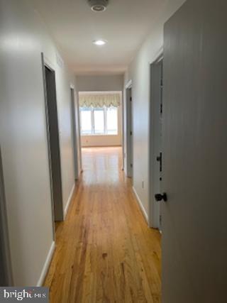 hall featuring baseboards and light wood finished floors