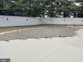 view of swimming pool featuring a patio and fence