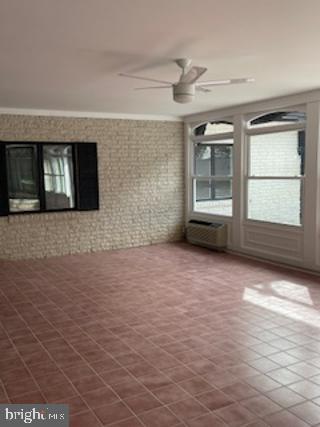 interior space with a ceiling fan and a wall mounted AC