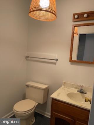 bathroom with baseboards, vanity, and toilet